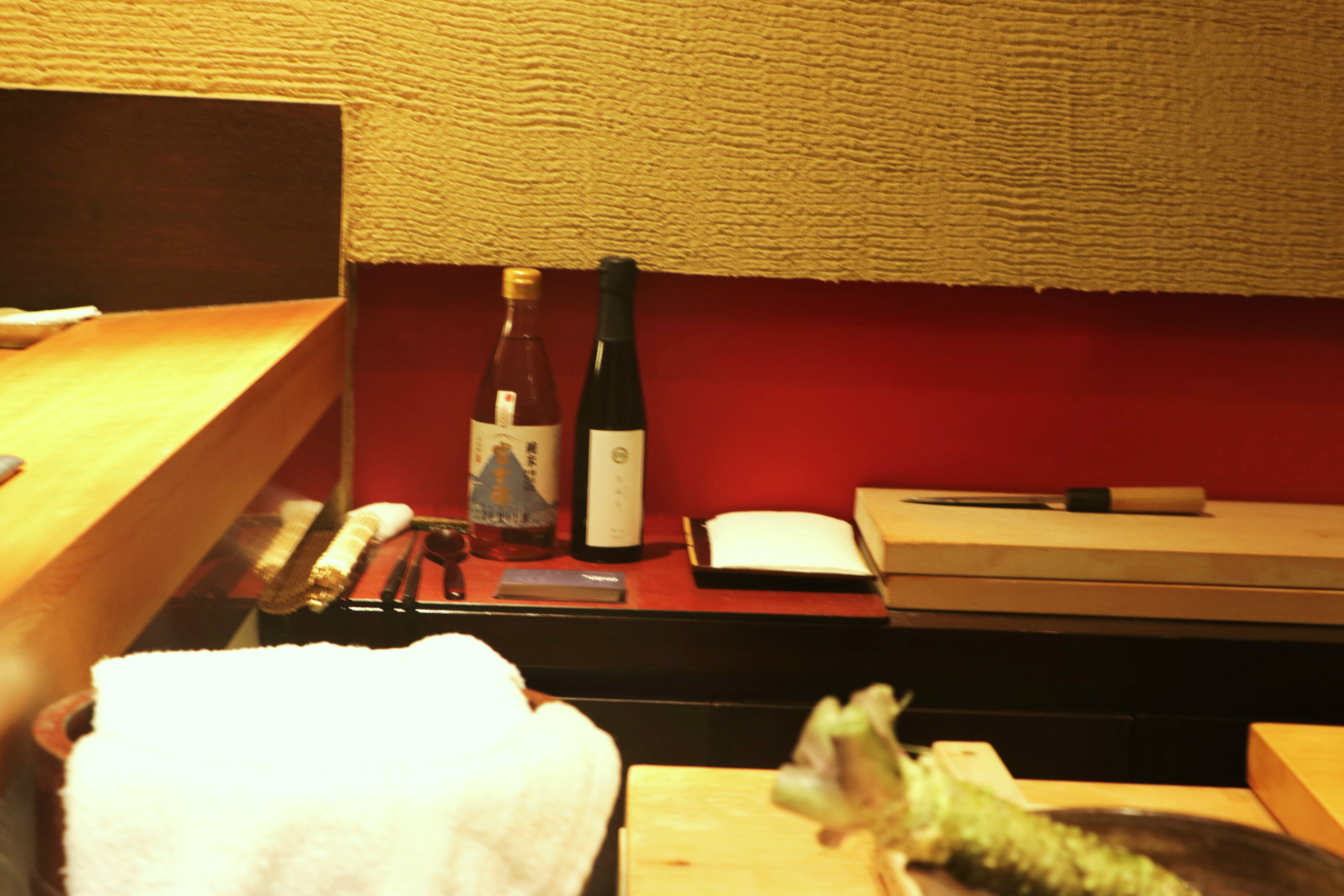 Chef Kimura proudly exhibits a bottle of Iio Jozo rice vinegar (left) behind his sushi counter. Credit: Copyright 2016 Hiroko Shimbo